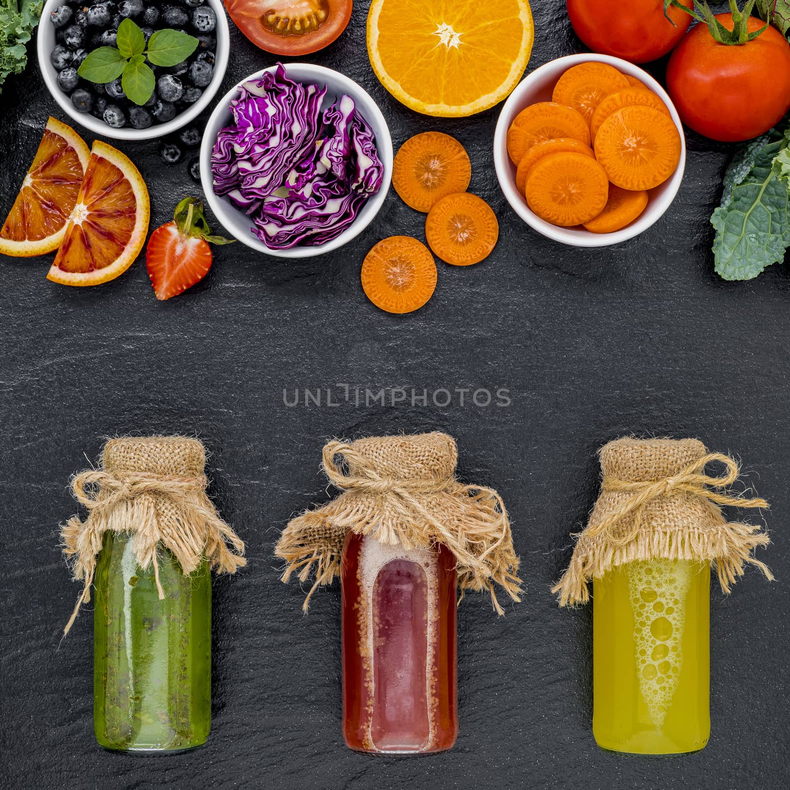 Colourful healthy smoothies and juices in bottles with fresh tro by kerdkanno