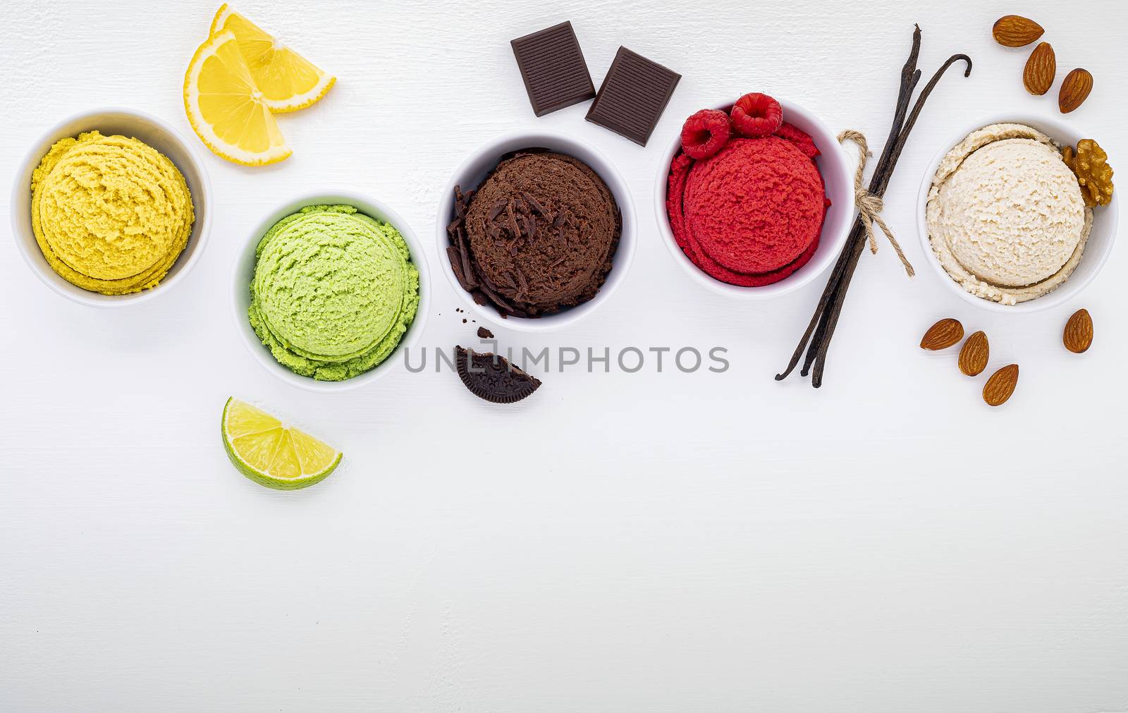 Various of ice cream flavor ball blueberry ,lime ,pistachio ,almond ,orange ,chocolate and vanilla set up on white wooden background . Summer and Sweet menu concept.