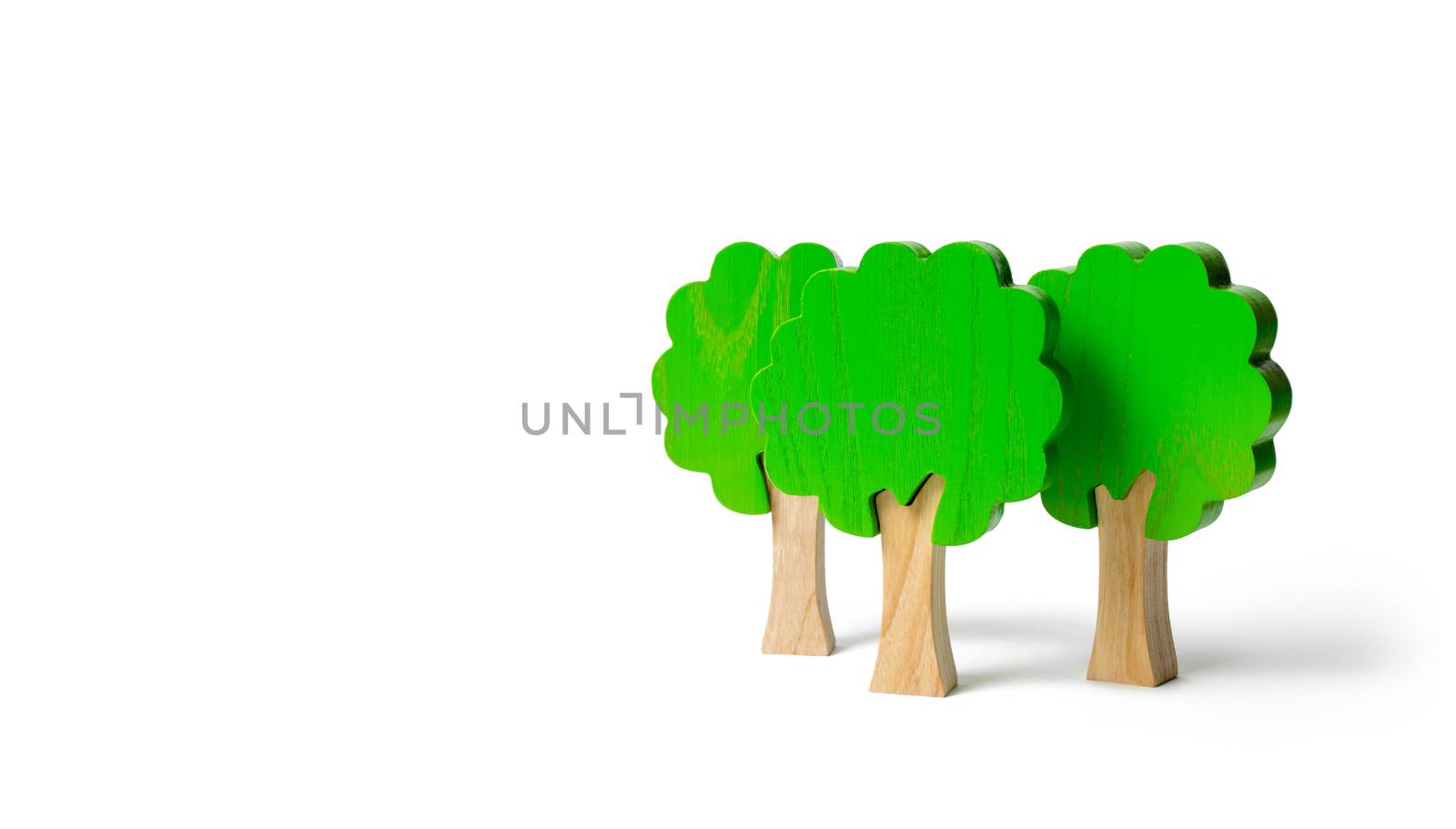 Three toy wooden figures of trees on an isolated background. Forest imitation. environmental conservation. Light planets. Family tree, a symbol of strength and wisdom. Illegal deforestation.