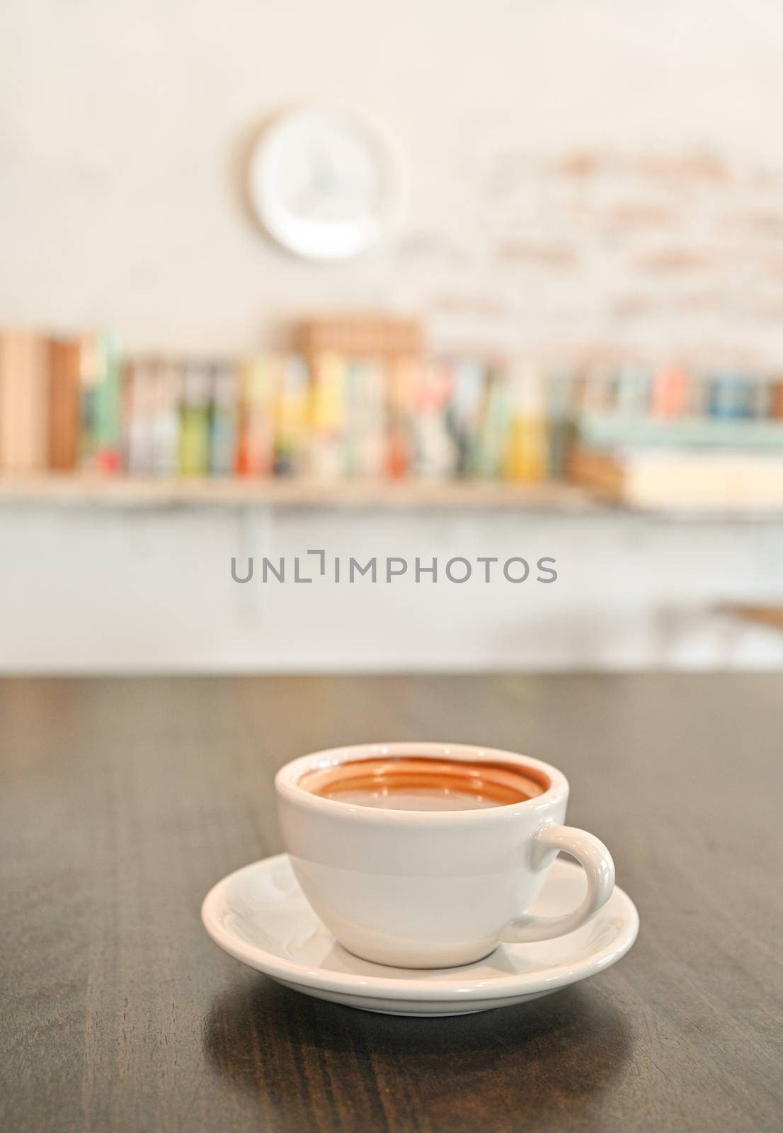 White coffee mug on wooden table, background, bookshelf. by poungsaed