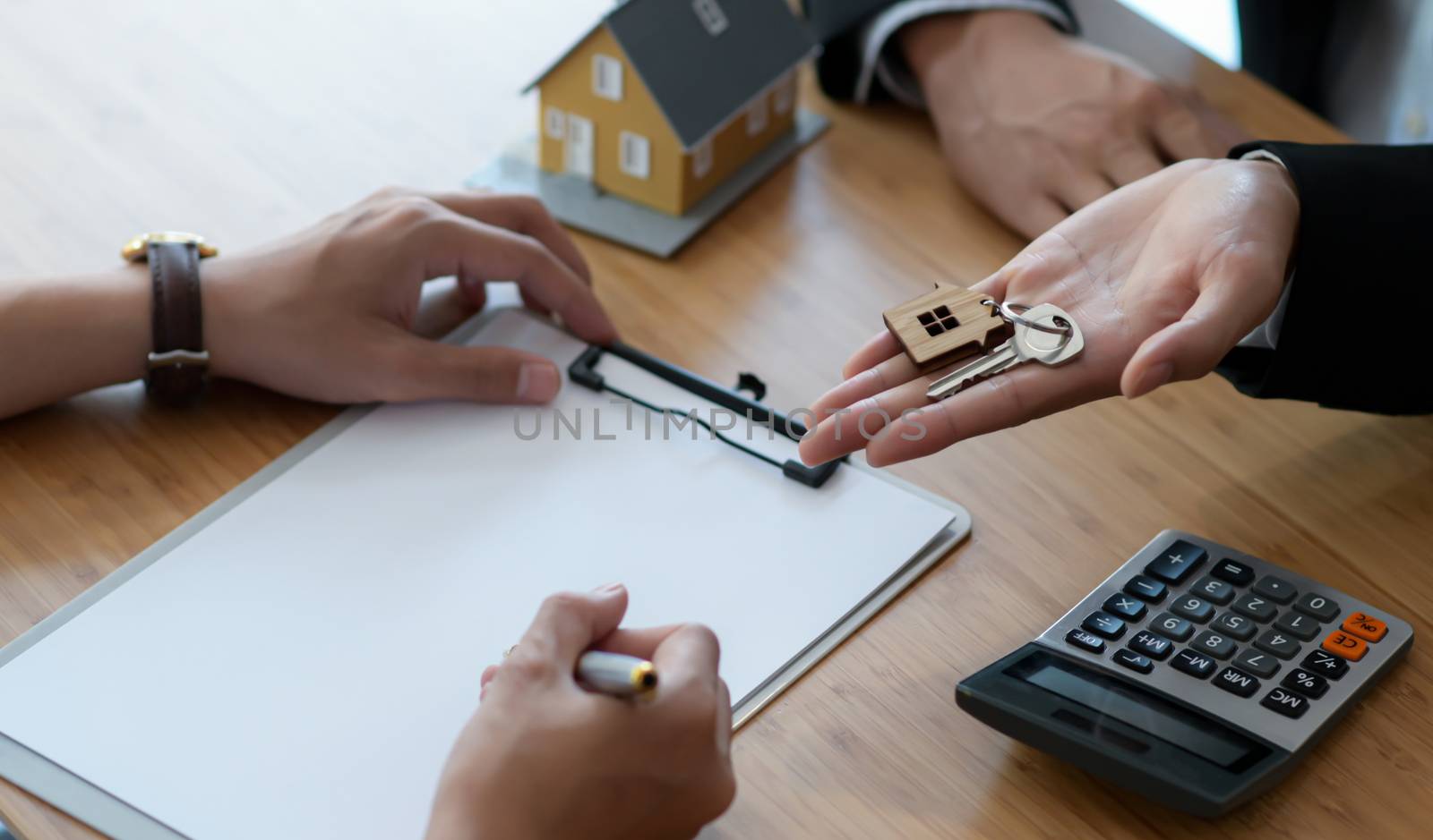 Signing a house purchase contract between the buyer and the seller and delivering the house key.