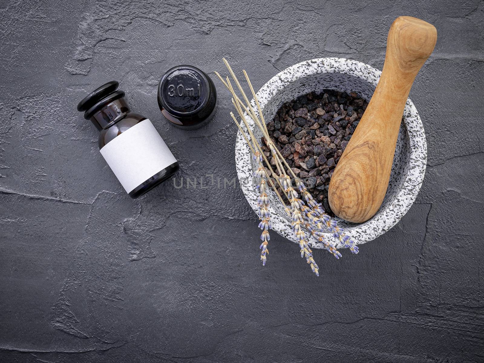 Aromatic  bath salt with lavender flower on dark concrete background. Himalayan salt commonly used in cooking and for bath products such as bath salts.