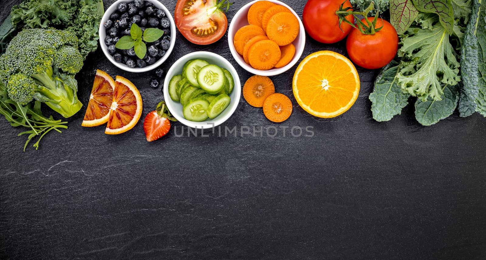 Colourful ingredients for healthy smoothies and juices on dark stone background with copy space.