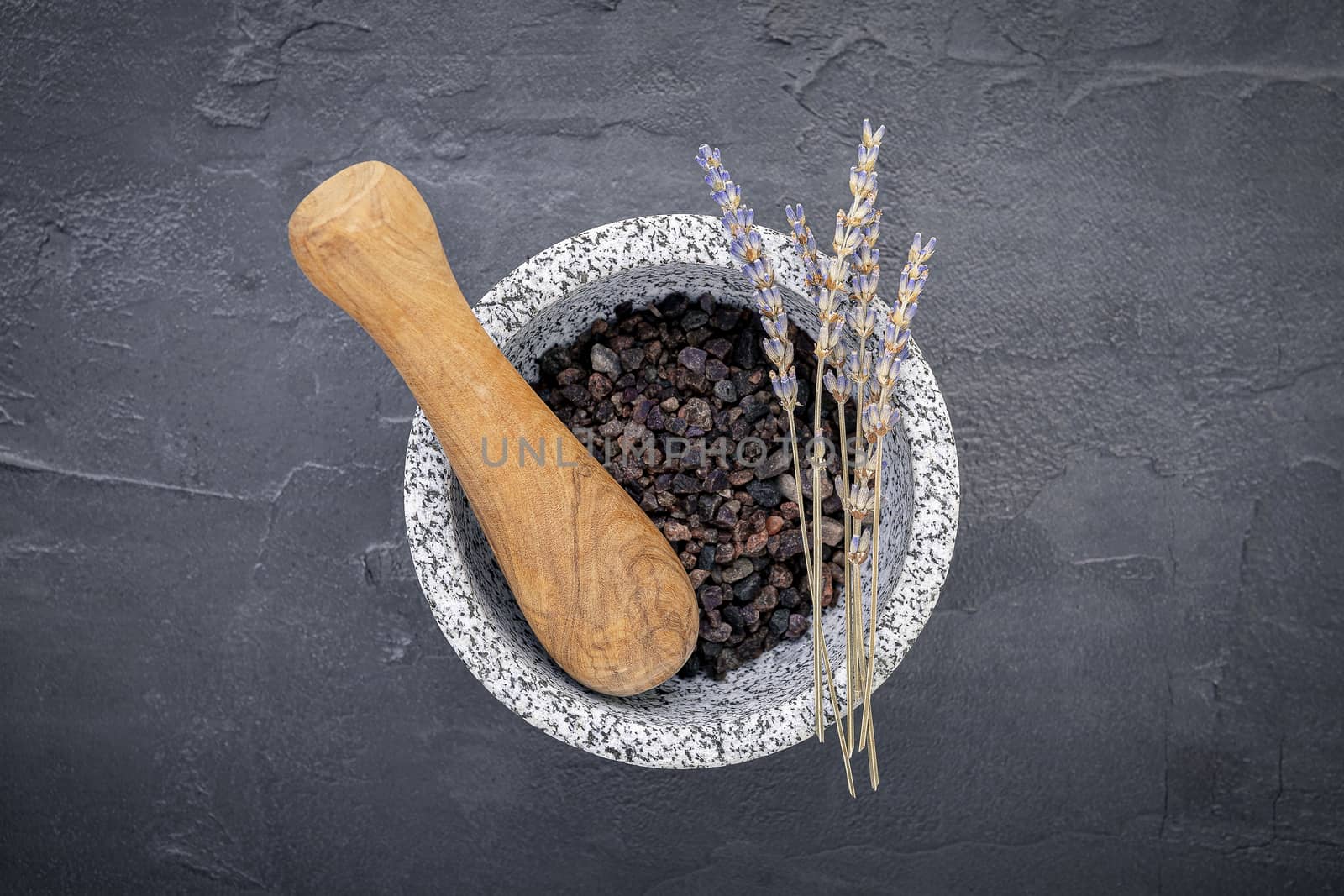 Aromatic  bath salt with lavender flower on dark concrete background. Himalayan salt commonly used in cooking and for bath products such as bath salts.