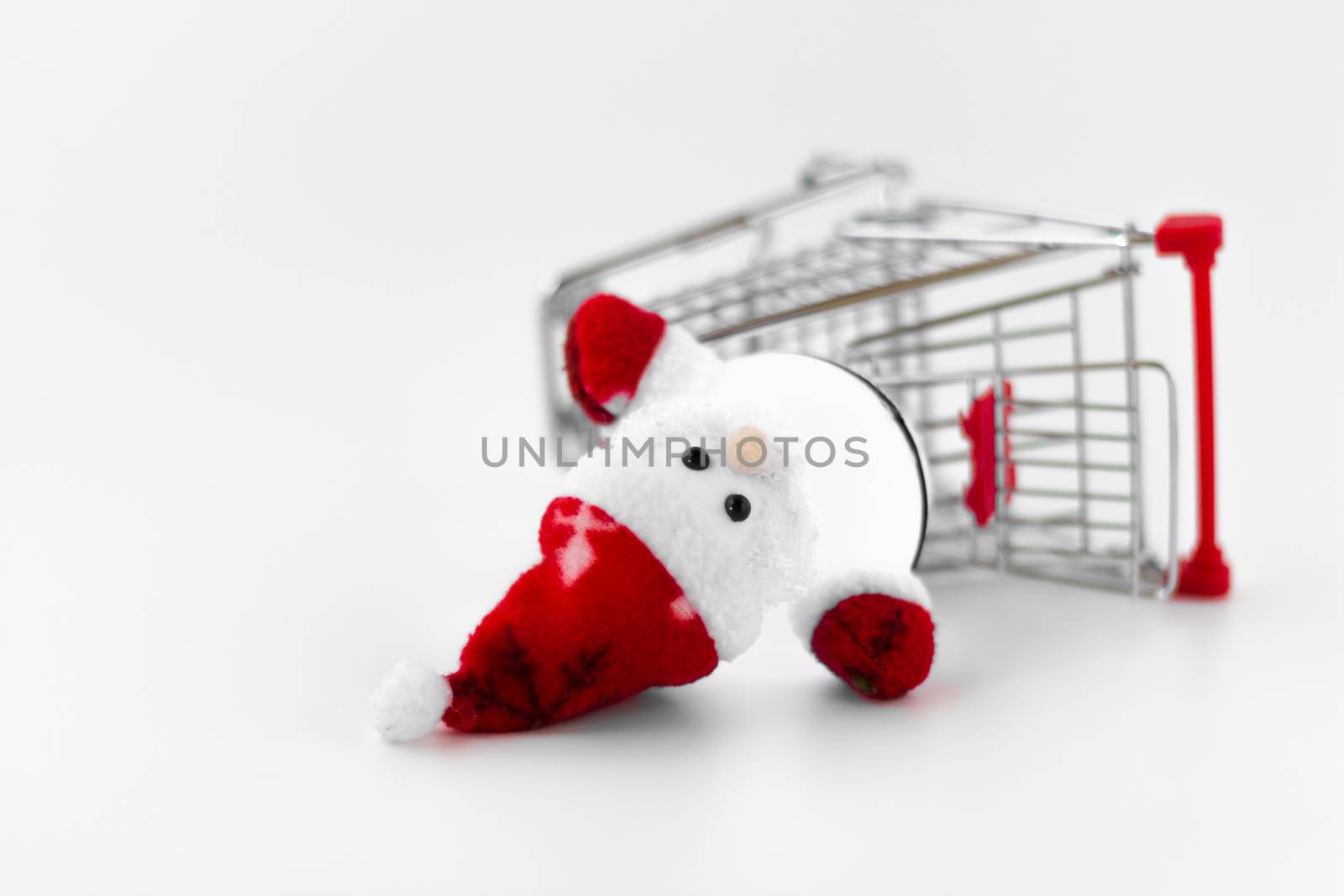 Santa Claus dropped out from the shopping cart. A conceptual representation of wrong gift or forgotten. Of rampant consumerism and the loss of the true spirit of Christmas. Shallow DOF.