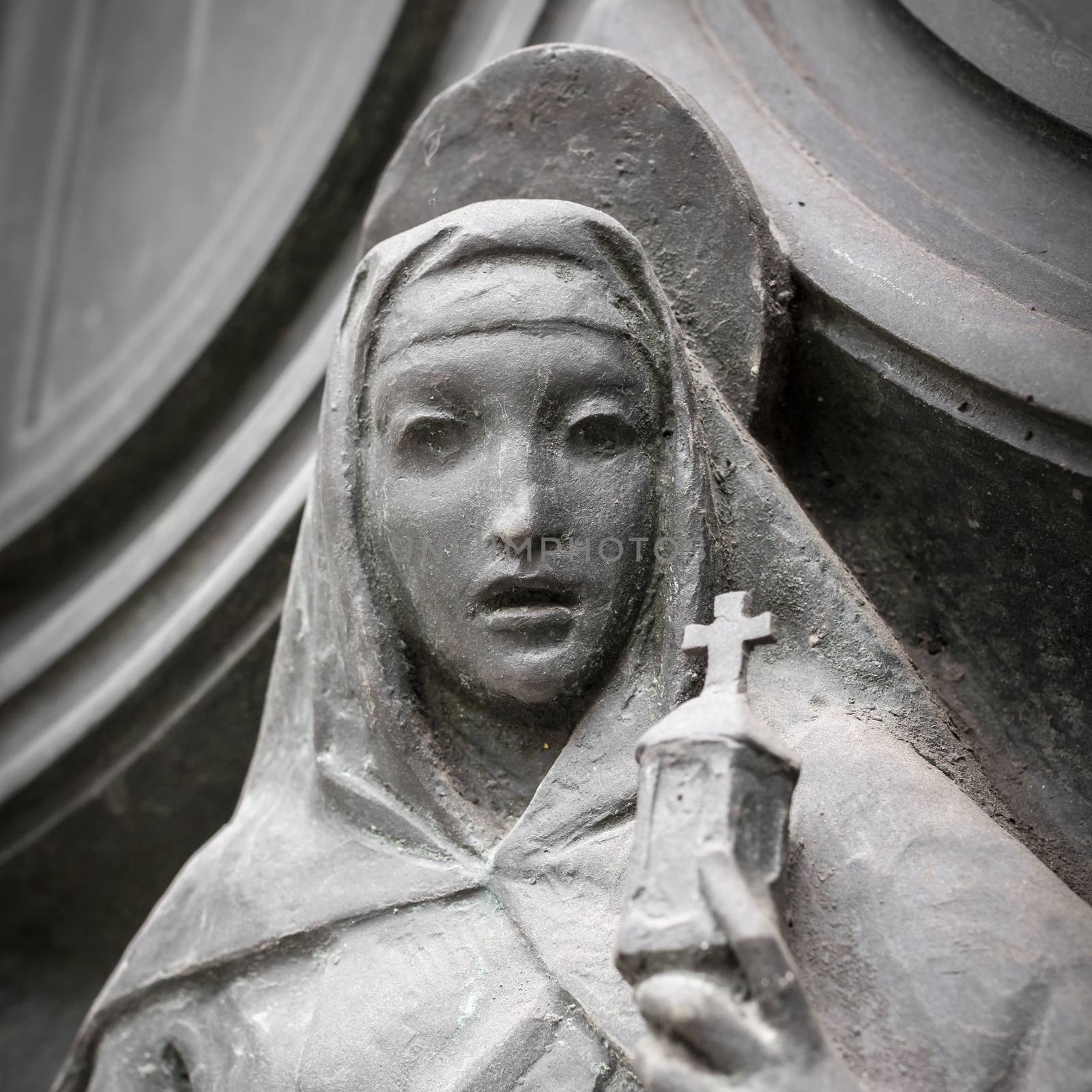 Stone statue of the Our Lady, with a surprised expression.