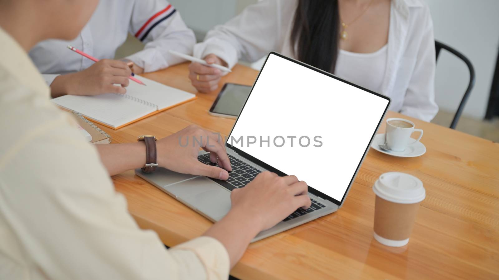 Cropped shot of A group of young professionals are searching for information from laptop and taking notes for management proposals for future projects.