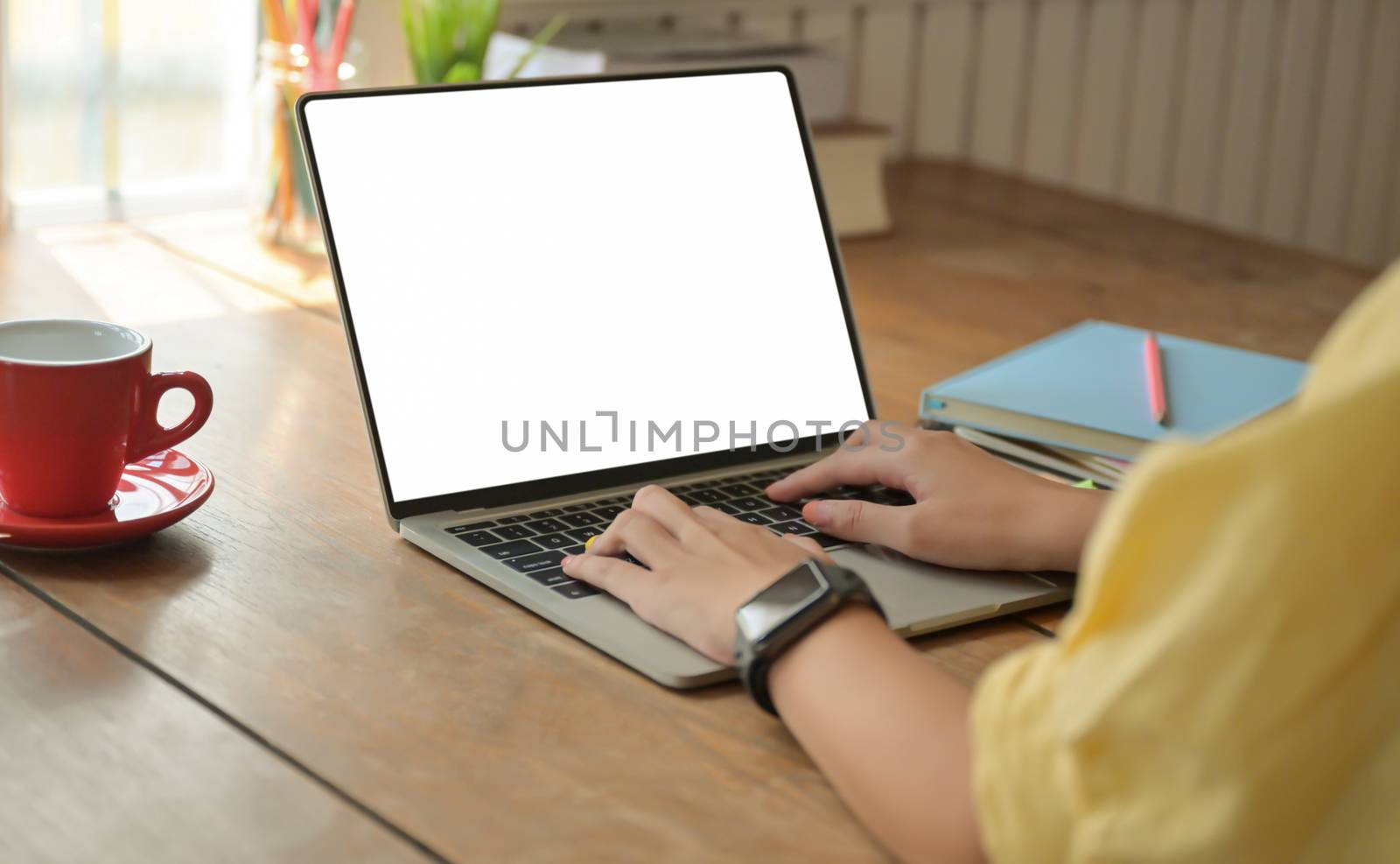 Cropped shot of A girl typing laptop keyboard on a desk with coffee cup , She works at home, Shot Taken from the back.