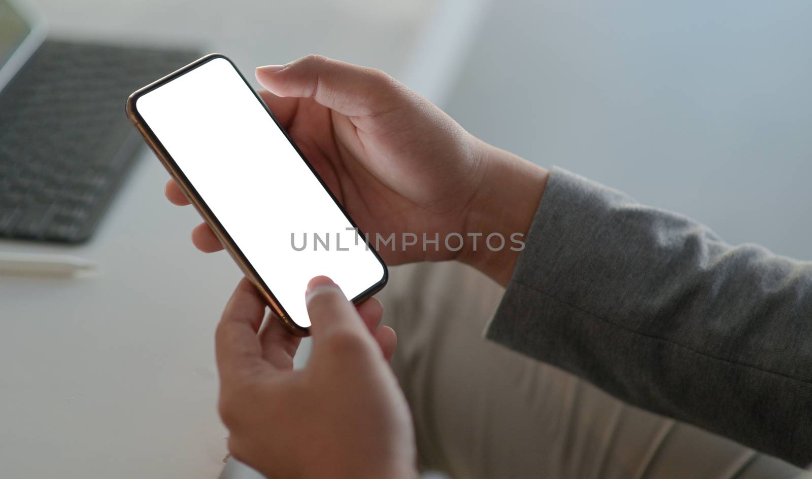 Cropped shot of A young executive holds a smartphone for online  by poungsaed