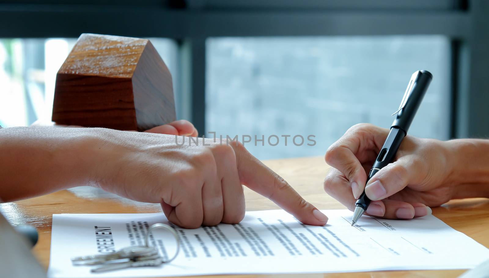 Close-up shot of The house broker pointed to the hand documents that customers signed a contract to buy a home loan.