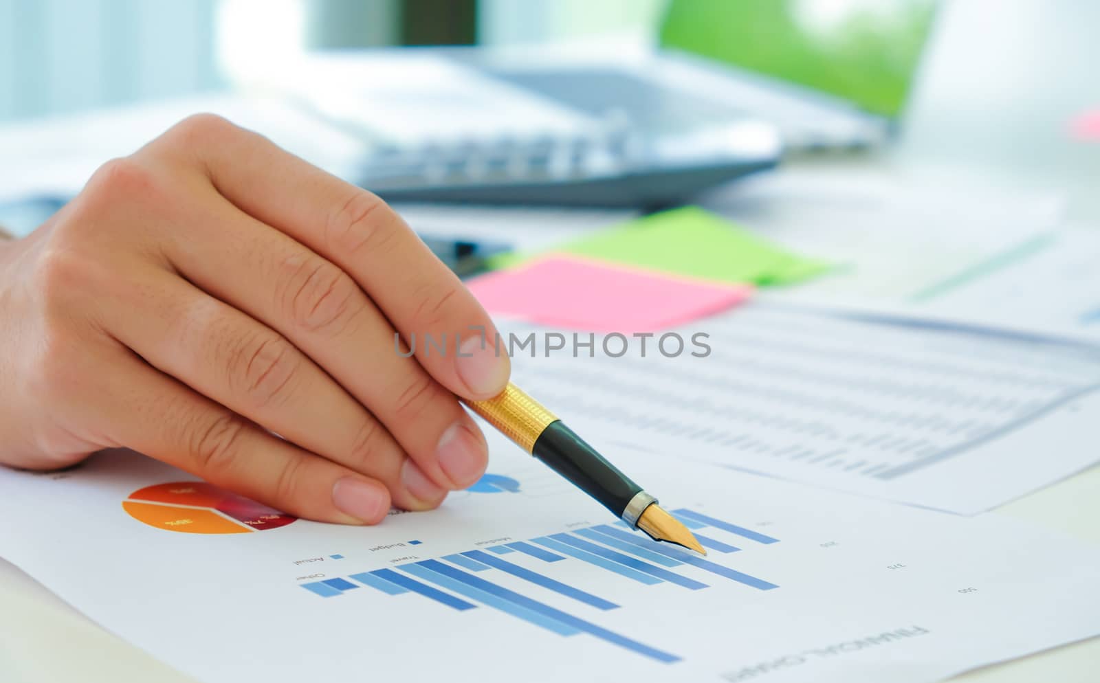 Close-up shot of Analysts use the pen to point the graph to assess the situation of the stock market that is fluctuating.