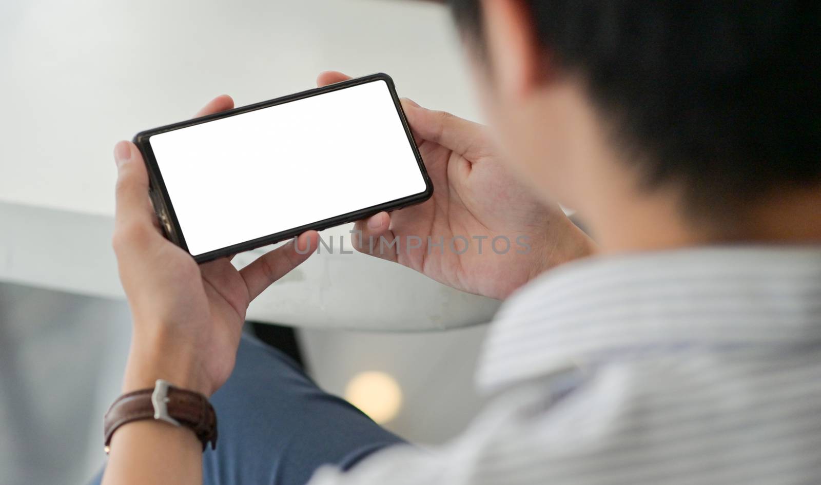 Close-up shot of a Business man using a blank screen smartphone.