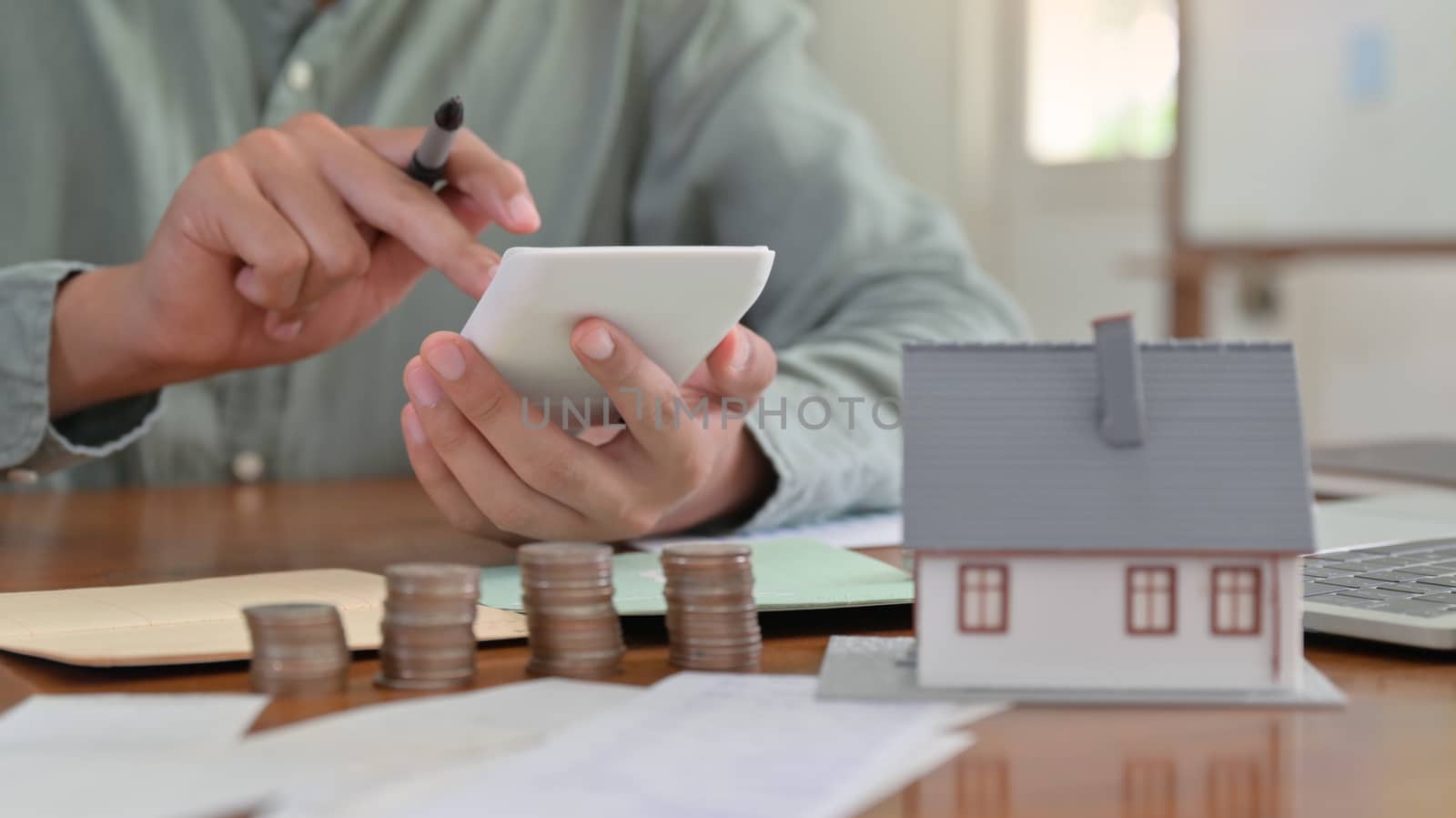 Hand is using calculator to calculate the home expenses.