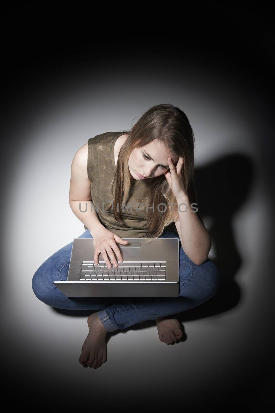 Young Woman Using Laptop In Pool Of Light