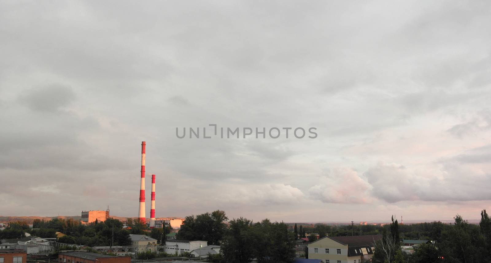 Evening industrial landscape with factory chimneys