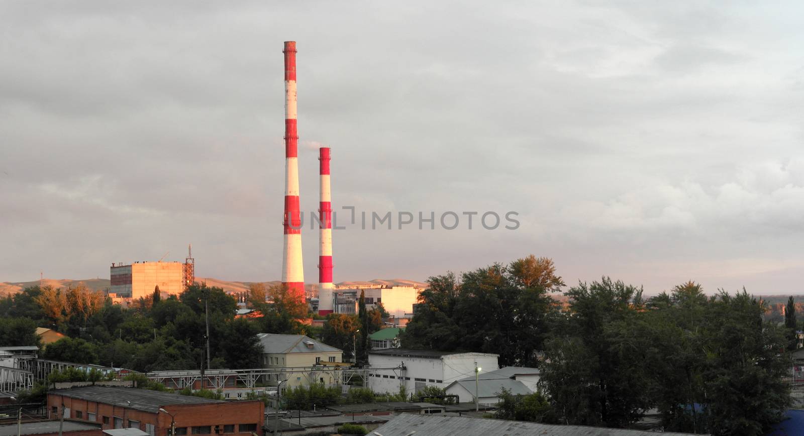 Evening industrial landscape with factory chimneys