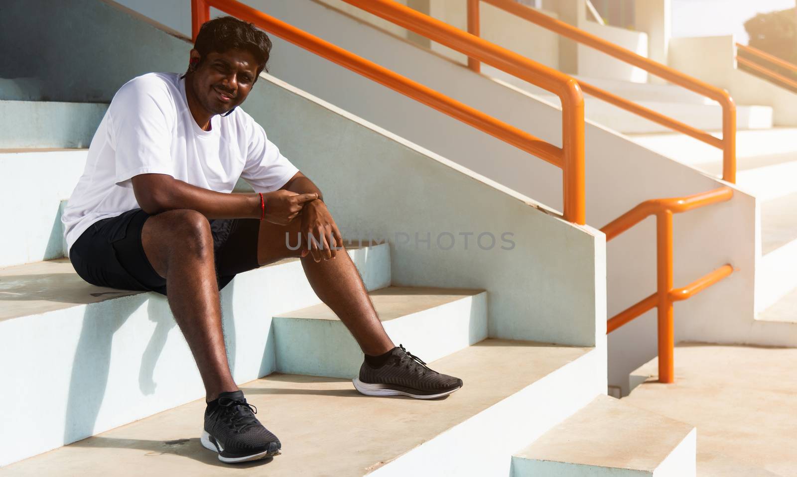 Close up Asian young athlete sport runner black man wear modern time smart watch he sitting resting before training running at the outdoor street health park, healthy exercise before workout concept