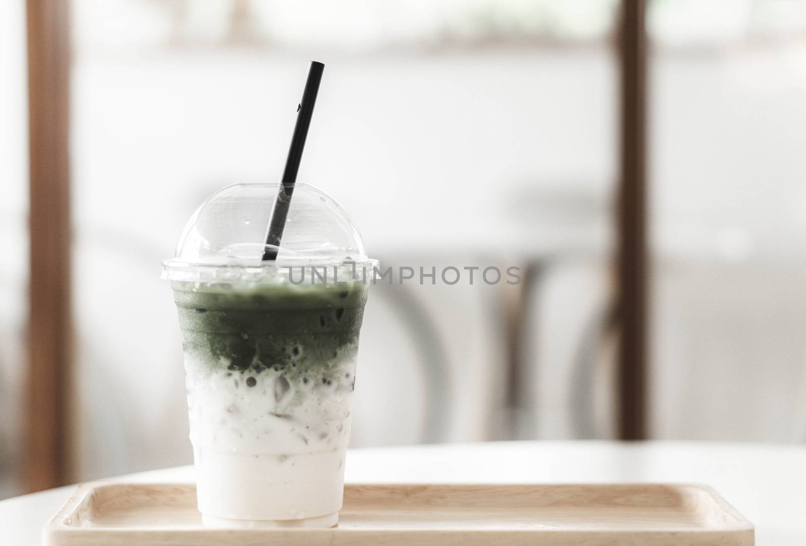 Closeup glass of matcha green tea shape on wood background with vintage color, selective focus