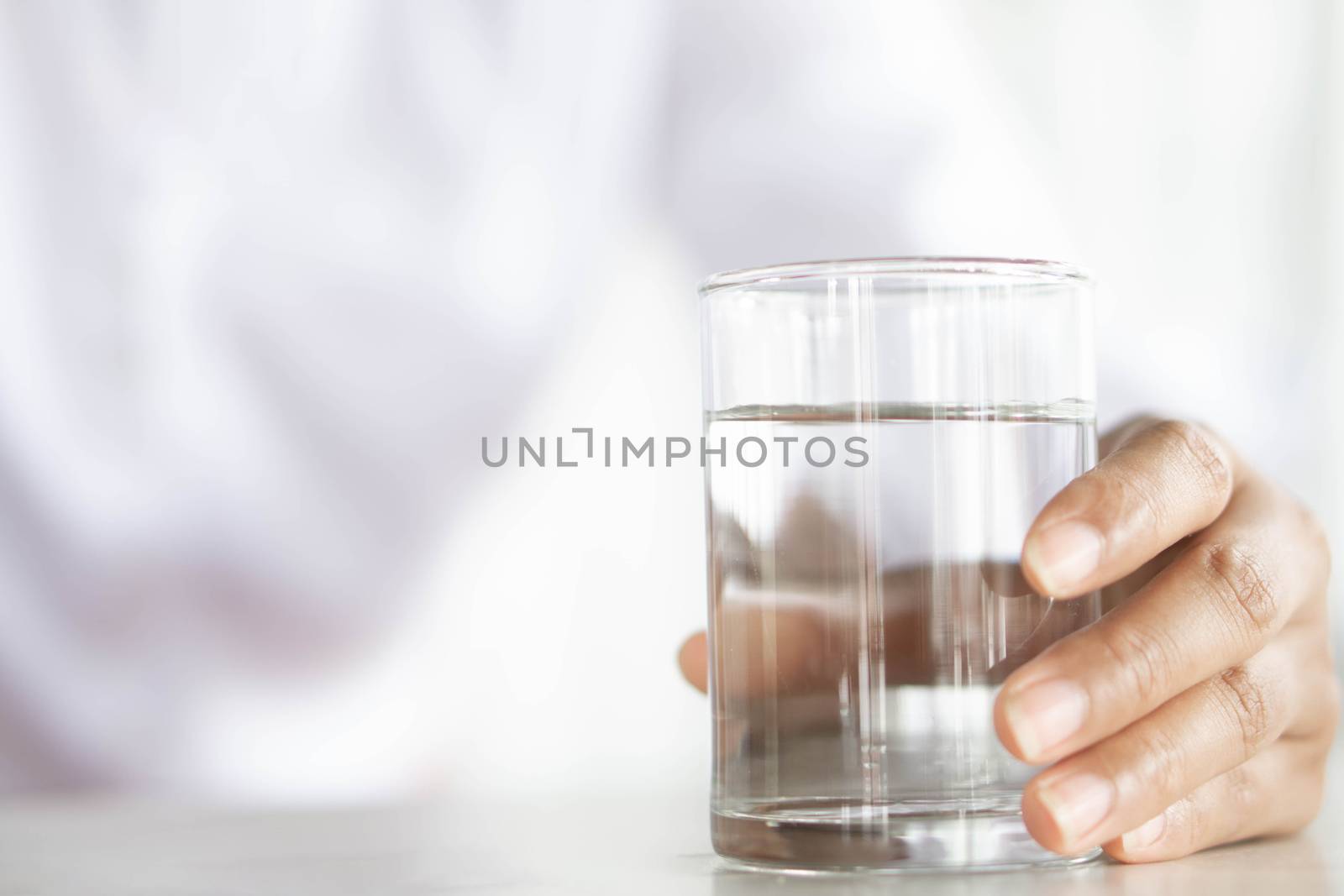 Close up woman hand holding a glass of pure water for dink on th by pt.pongsak@gmail.com