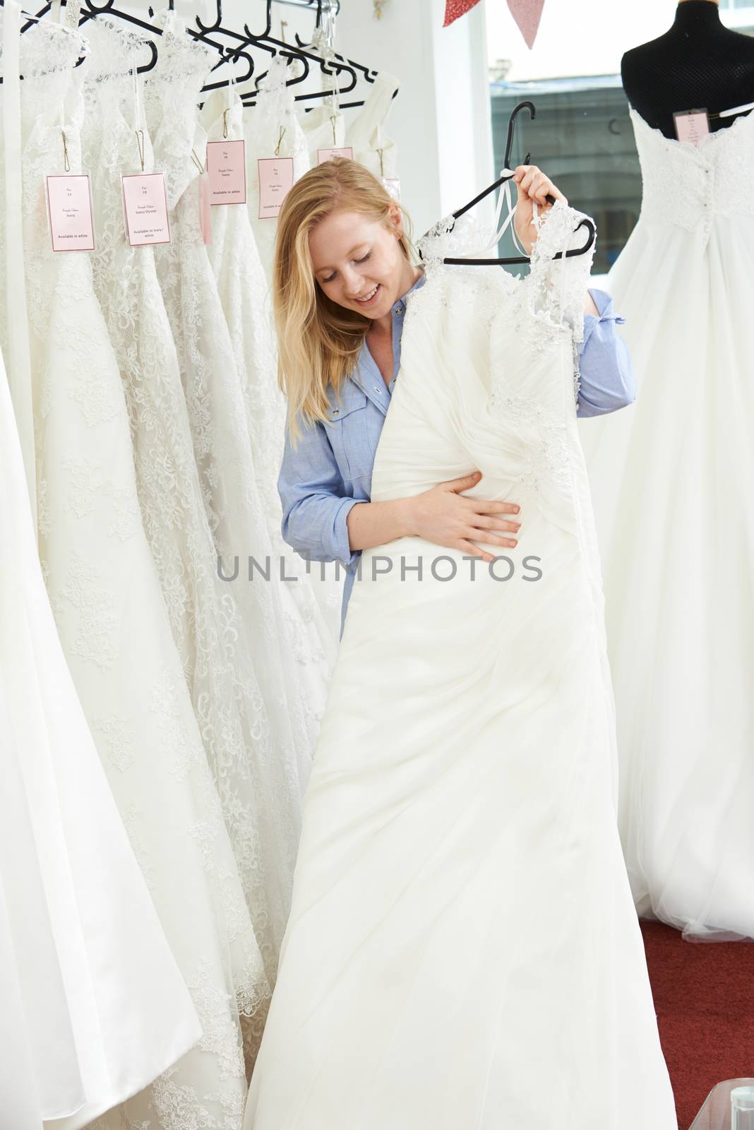 Bride Choosing Dress In Bridal Boutique by HWS