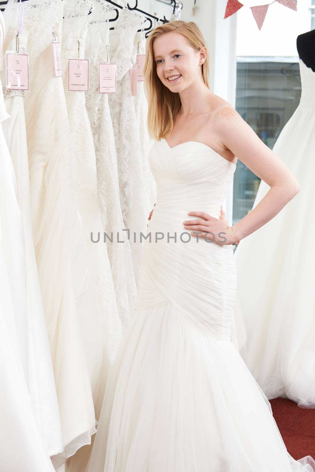 Bride Trying On Wedding Dress In Bridal Boutique