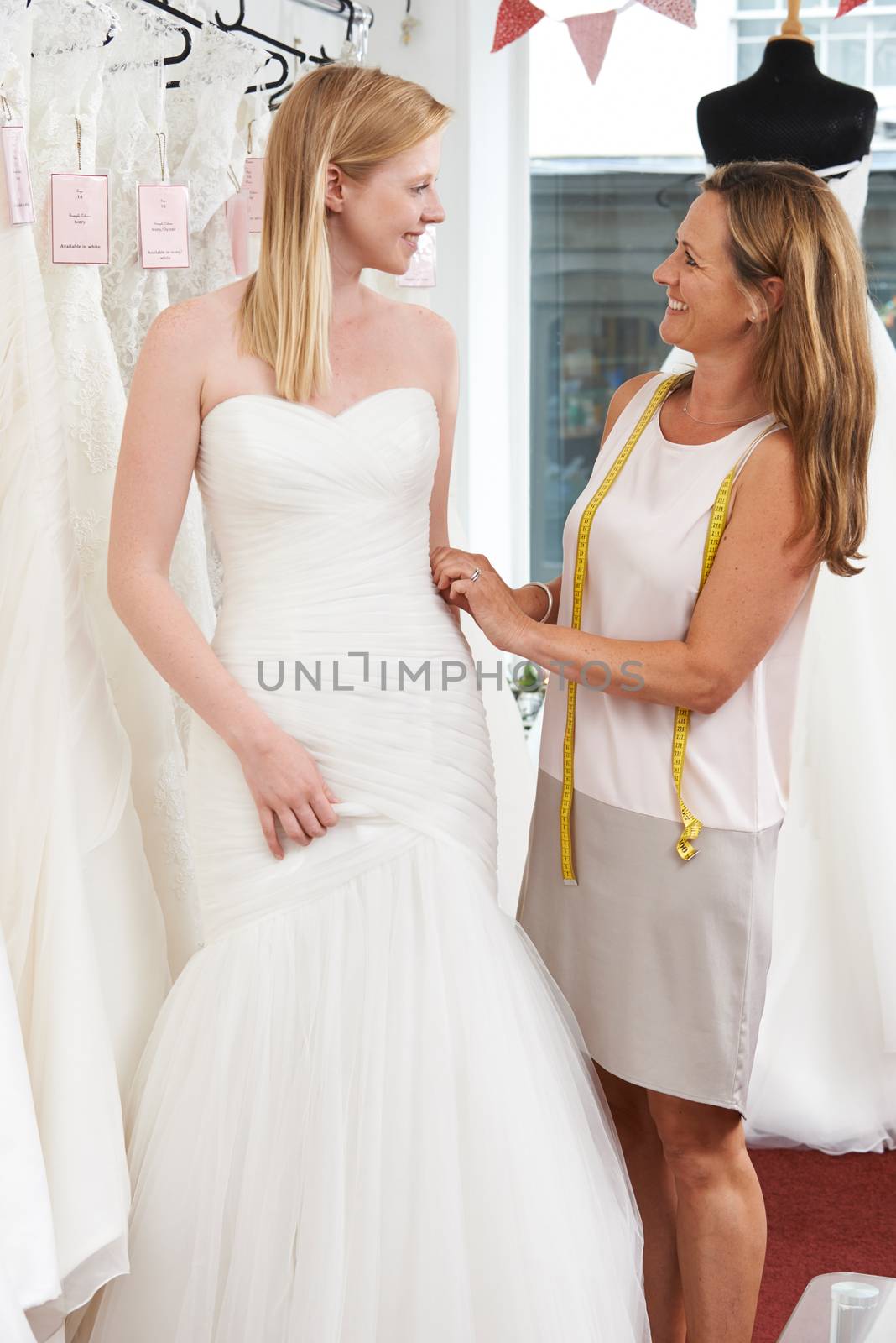 Bride Being Fitted For Wedding Dress By Store Owner by HWS