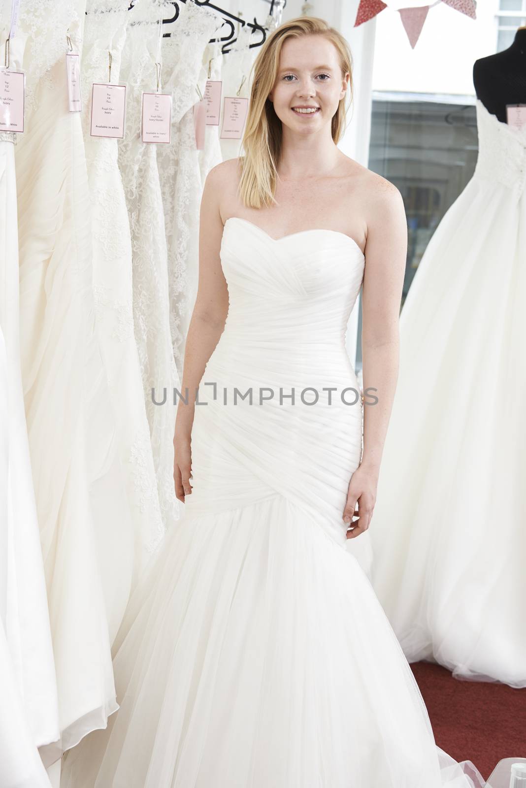 Bride Trying On Wedding Dress In Bridal Boutique