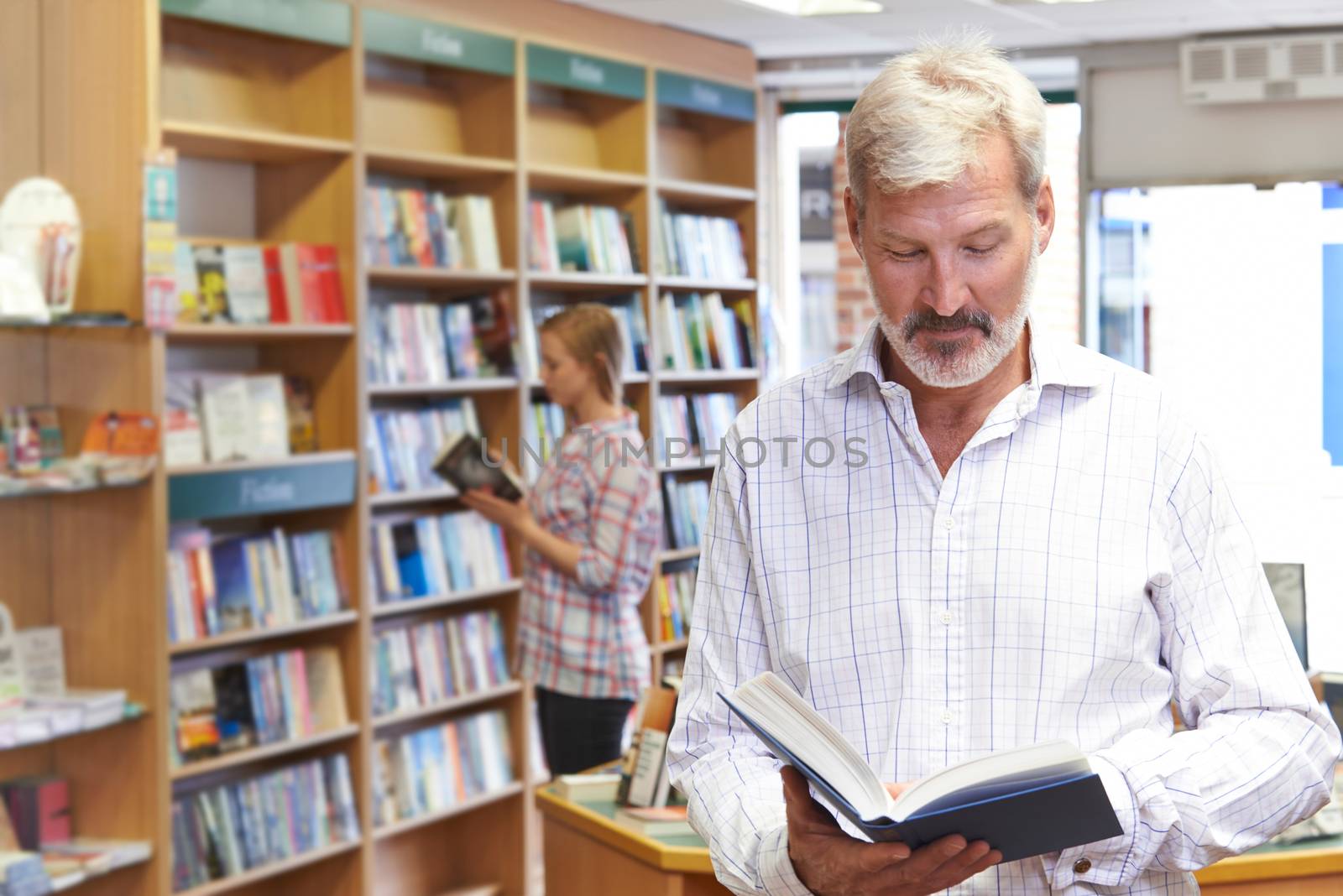 Customers Browsing Books In Bookshop by HWS