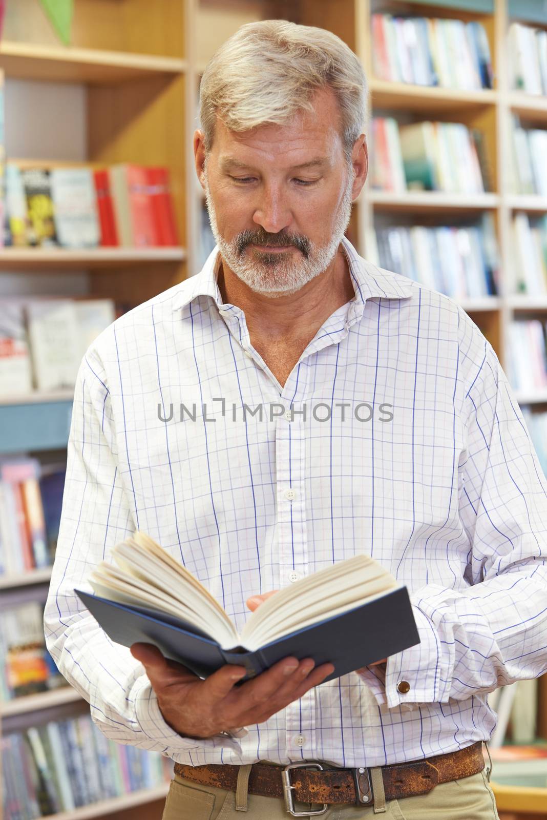 Male Customer Reading Book In Bookstore by HWS