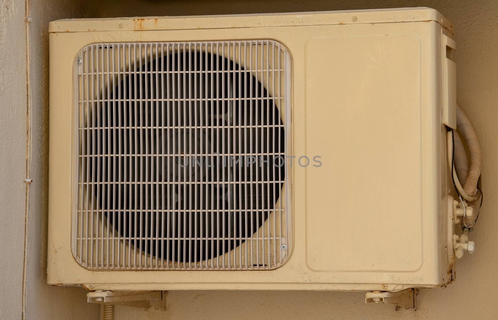Air conditioner unit compressor outside a home. Condenser Fan for support residential cooling system. conditioning equipment machinery hanging on exterior wall.  climate technology attached outdoor.