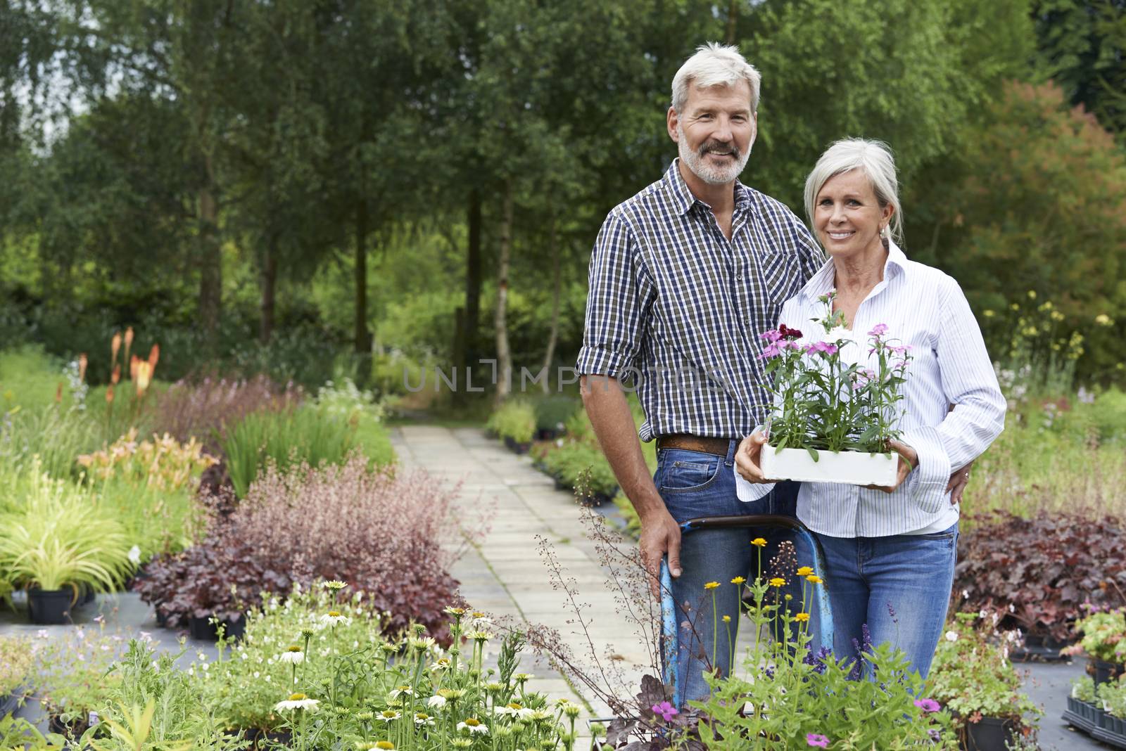 Portrait Of Mature Couple Shopping At Garden Center by HWS