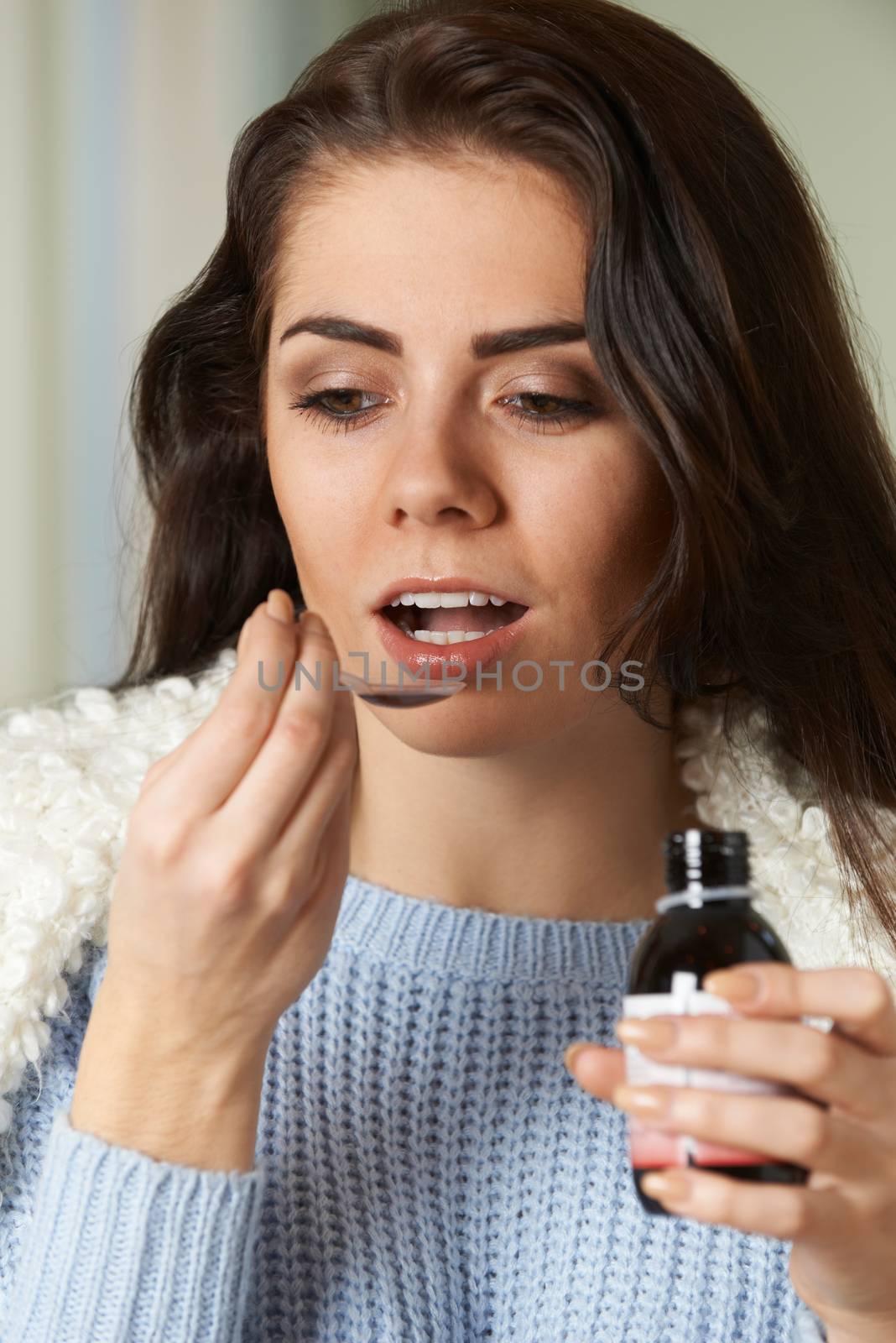 Woman With Cold Taking Medicine On Spoon