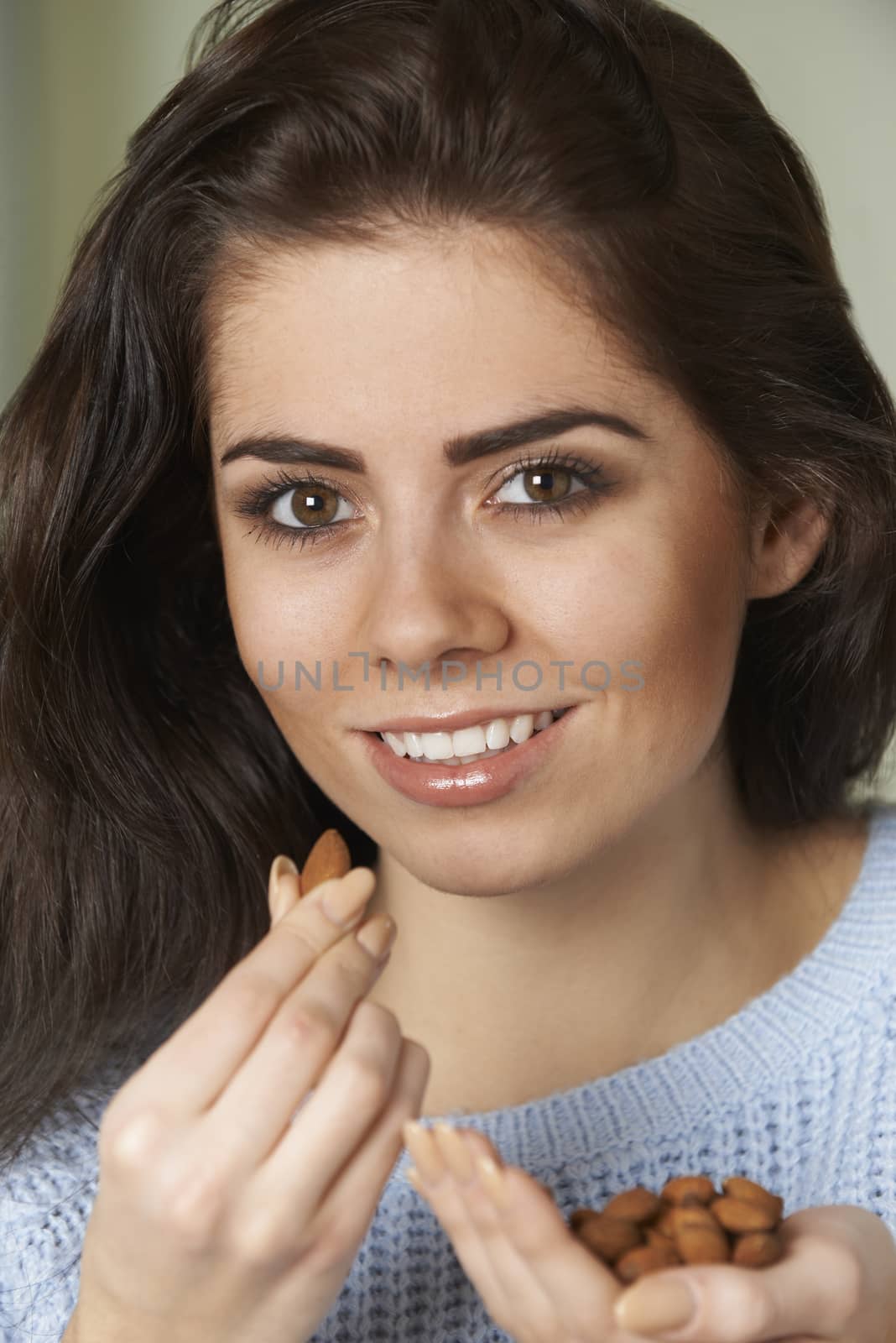Attractive Woman Eating Handful Of Almonds
