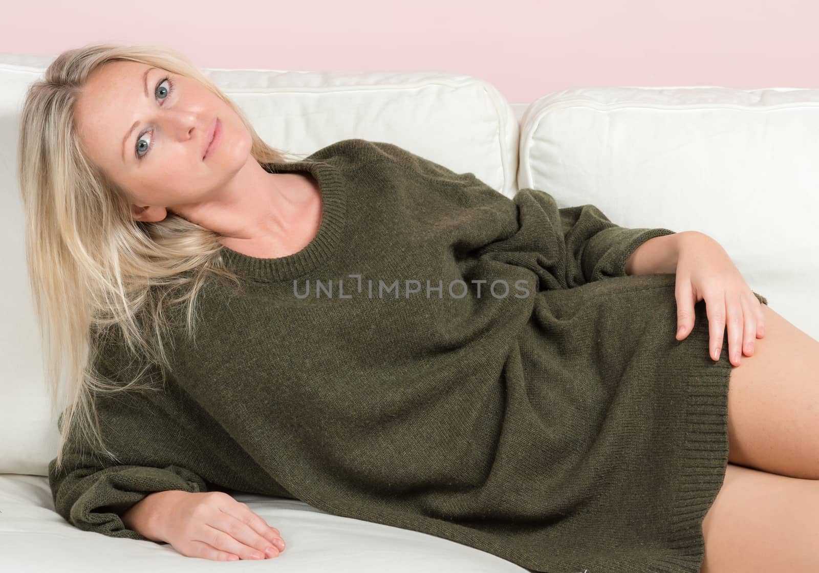 Beautiful tender woman in sweater is posing on a sofa by nemo269