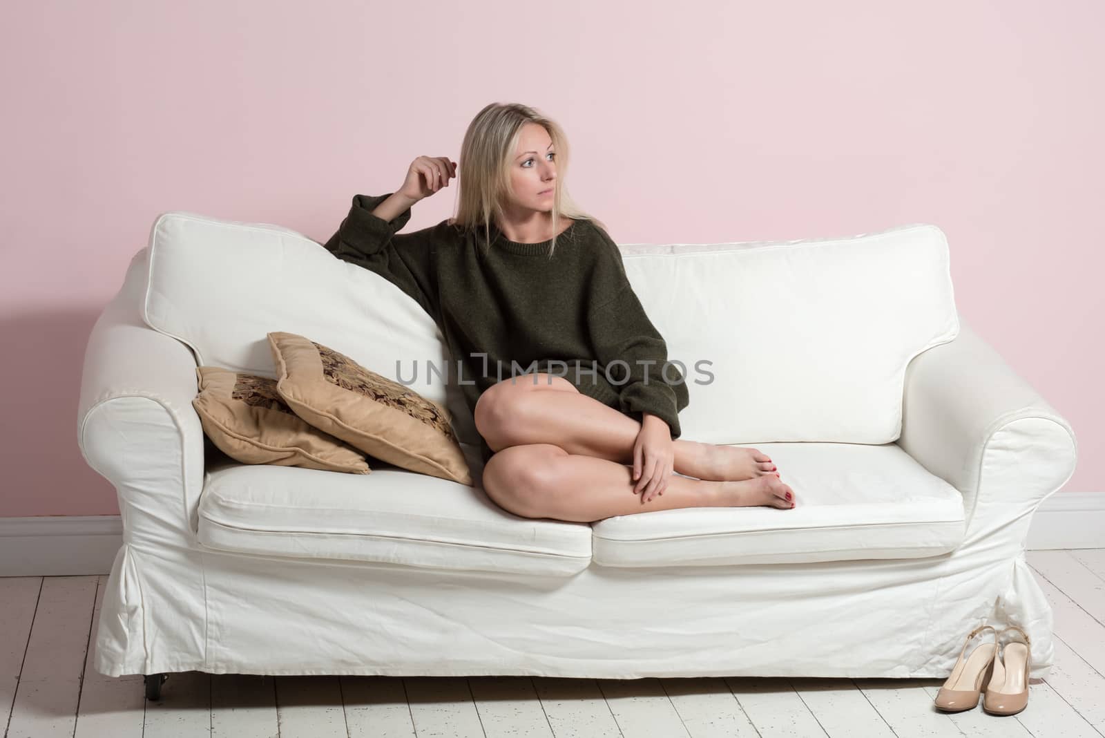 Beautiful tender woman in sweater is relaxing on a sofa by nemo269