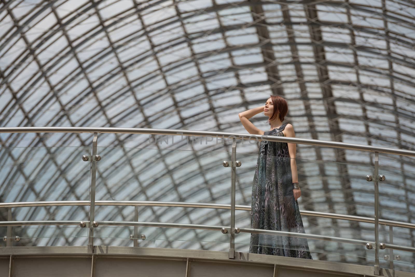 Charming lovely looking model in a glamour cloak is posing under the tracery roof