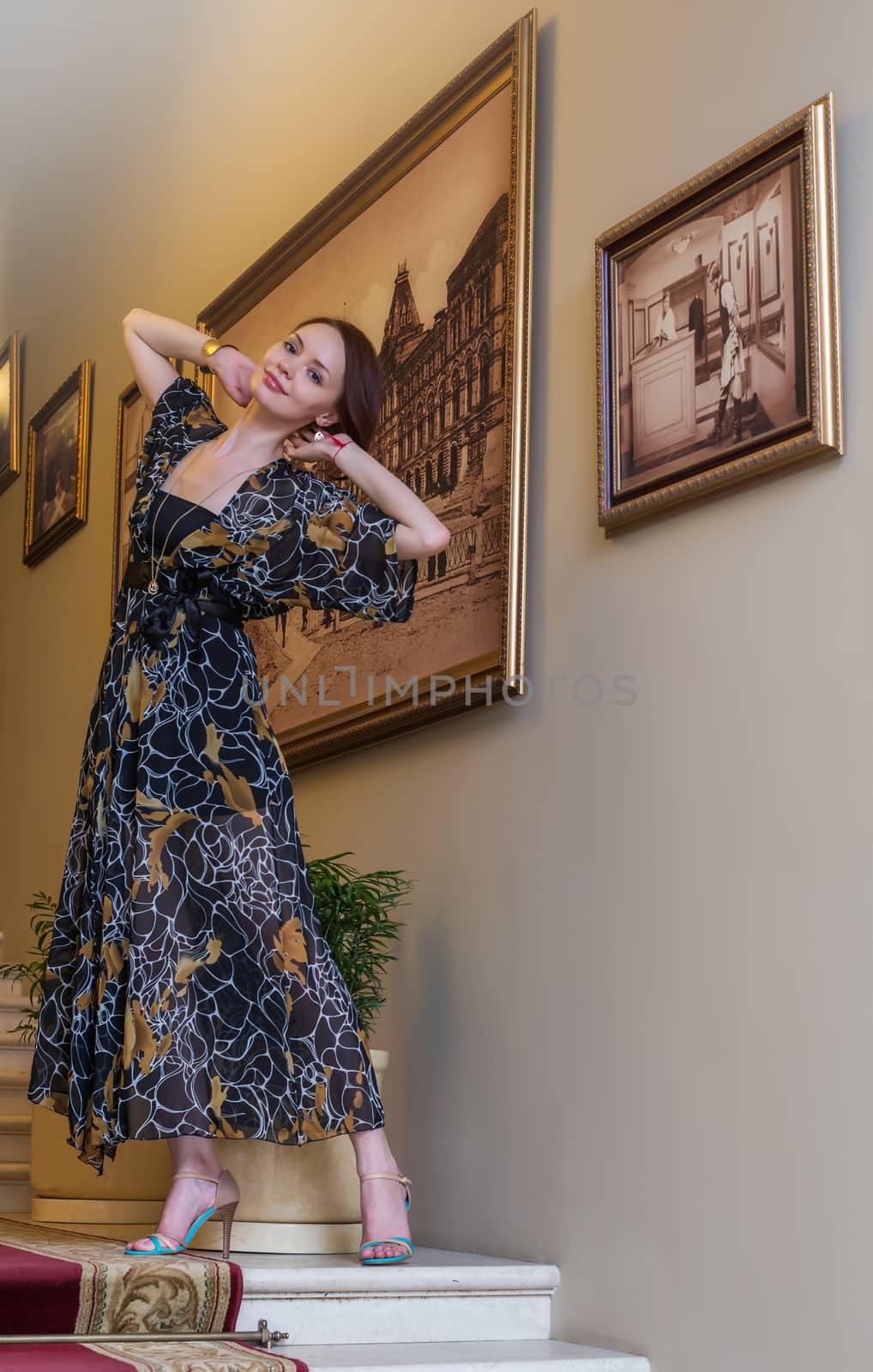 Charming tender lady in gauzy lengthy dress is posing at historic hall by nemo269