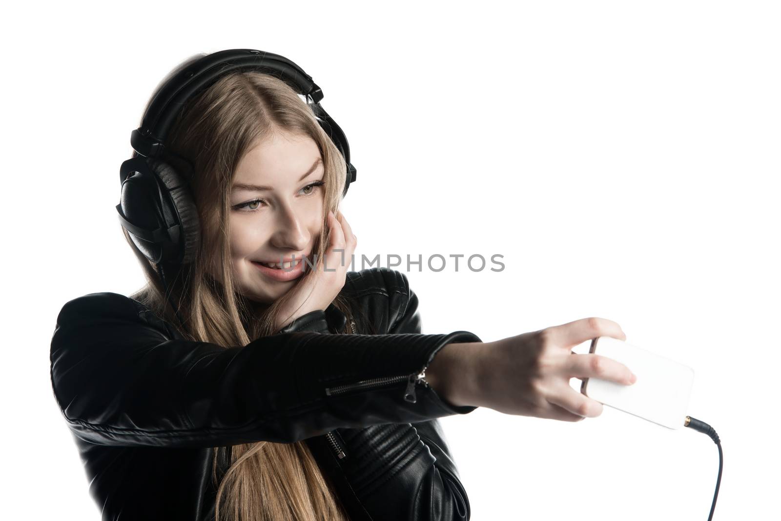 Isolated on white happy face of a girl making selfie and a grimace while listening music in wired headphones