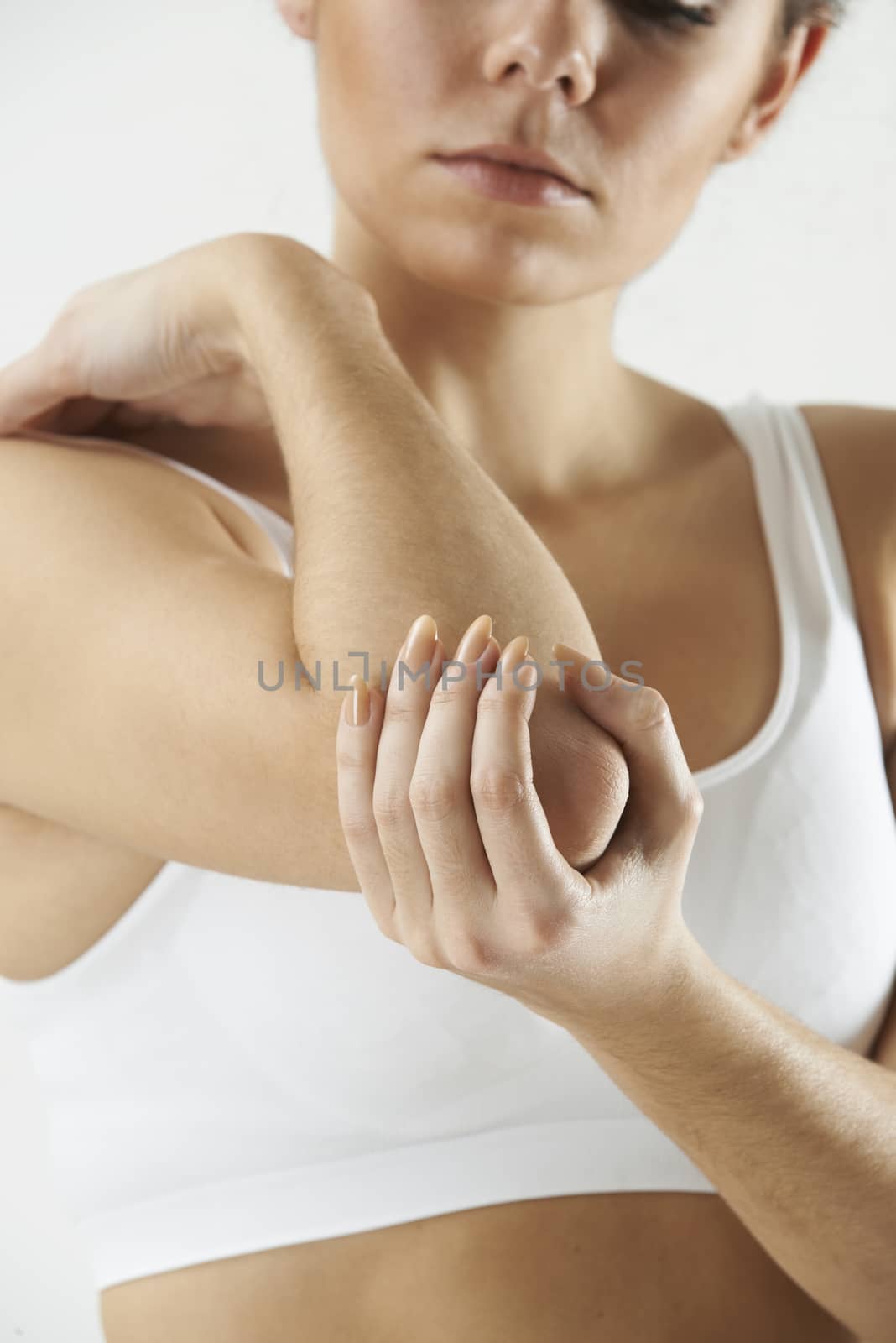 Studio Shot Of Woman With Painful Elbow by HWS