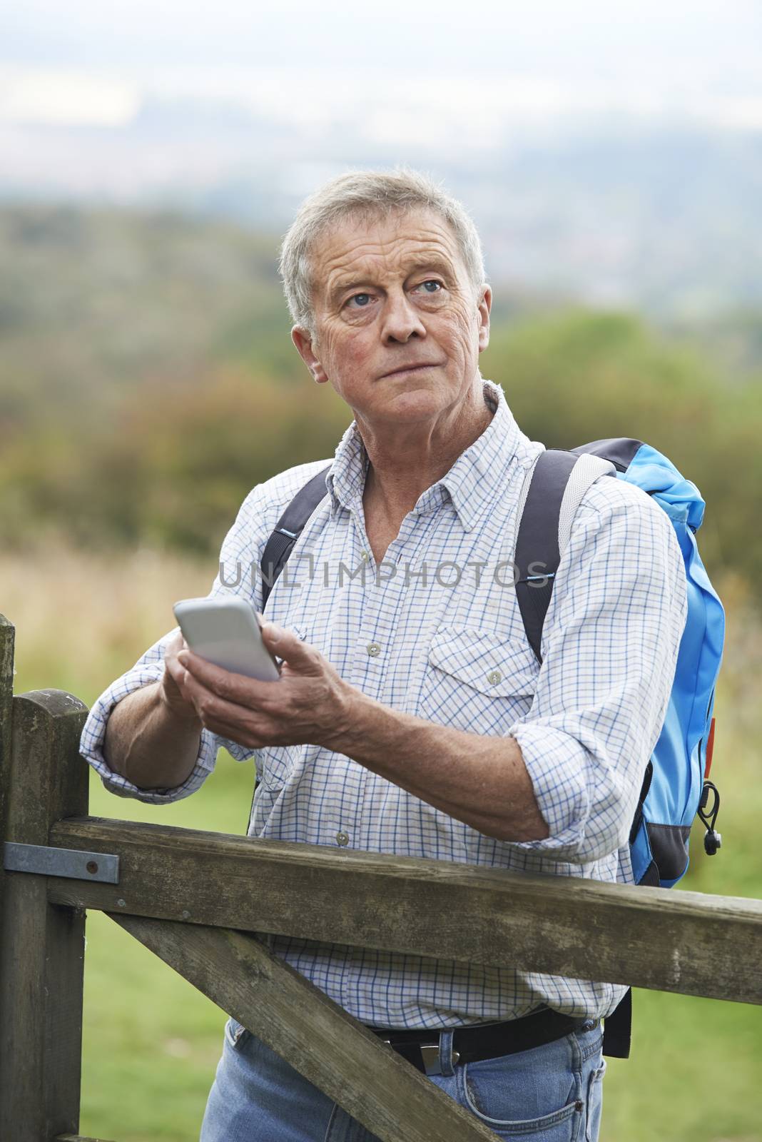 Senior Man Checking Location With Mobile Phone On Hike by HWS