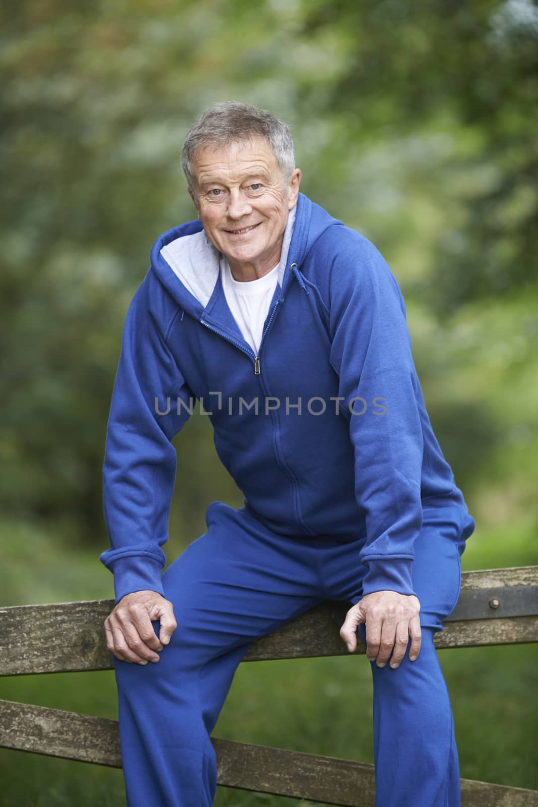 Senior Man Resting Whilst Exercising In Countryside by HWS