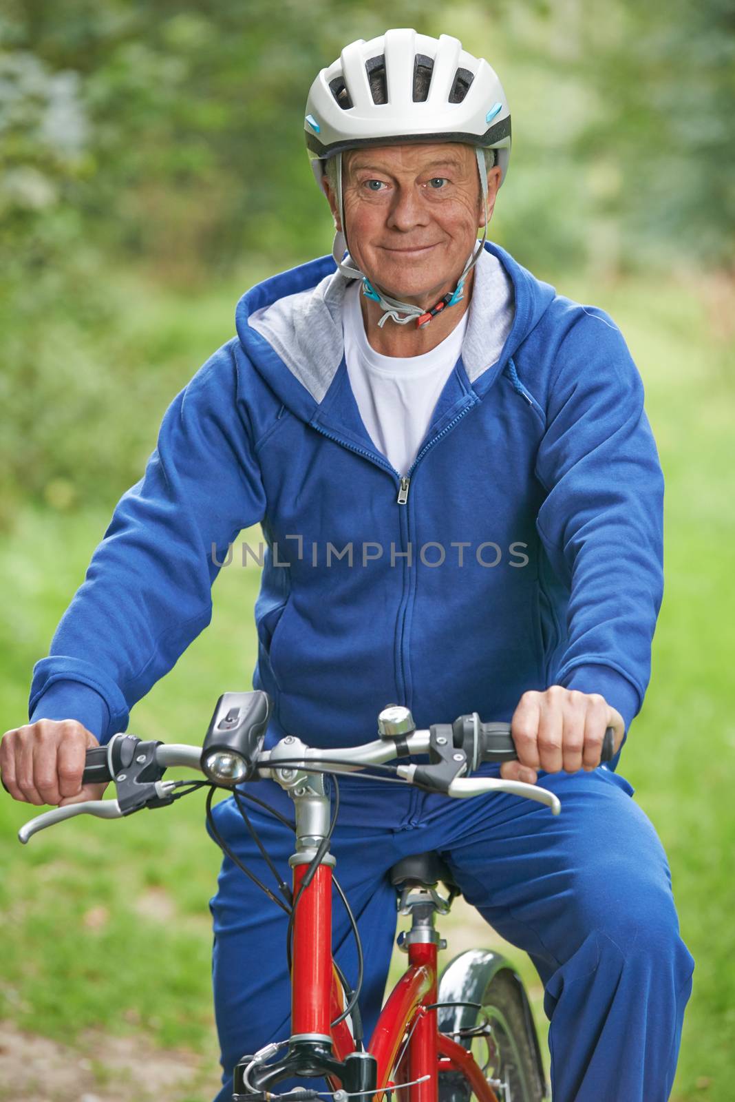 Senior Man Enjoying Cycle Ride In The Countryside