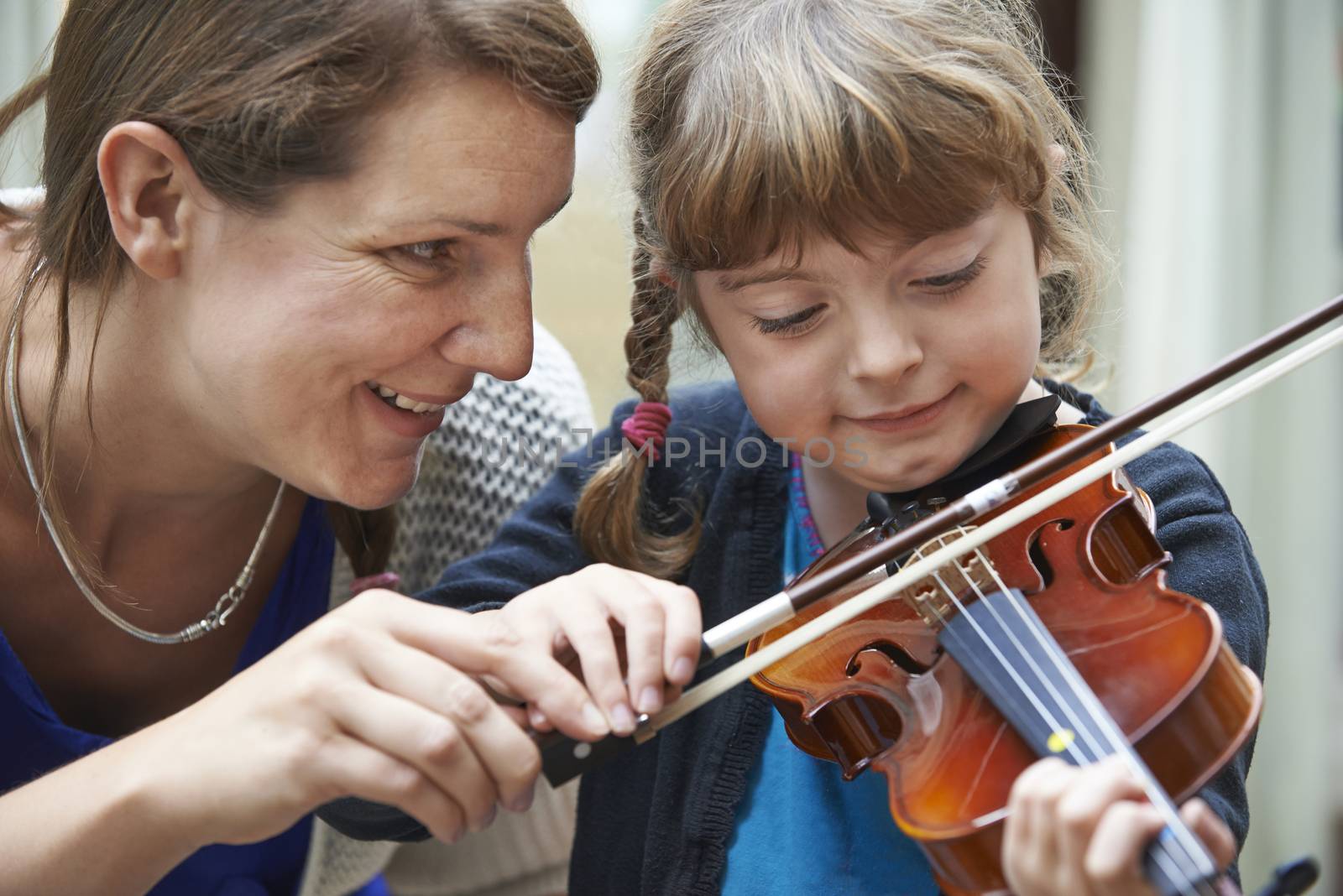 Teacher Helping Young Female Pupil In Violin Lesson by HWS