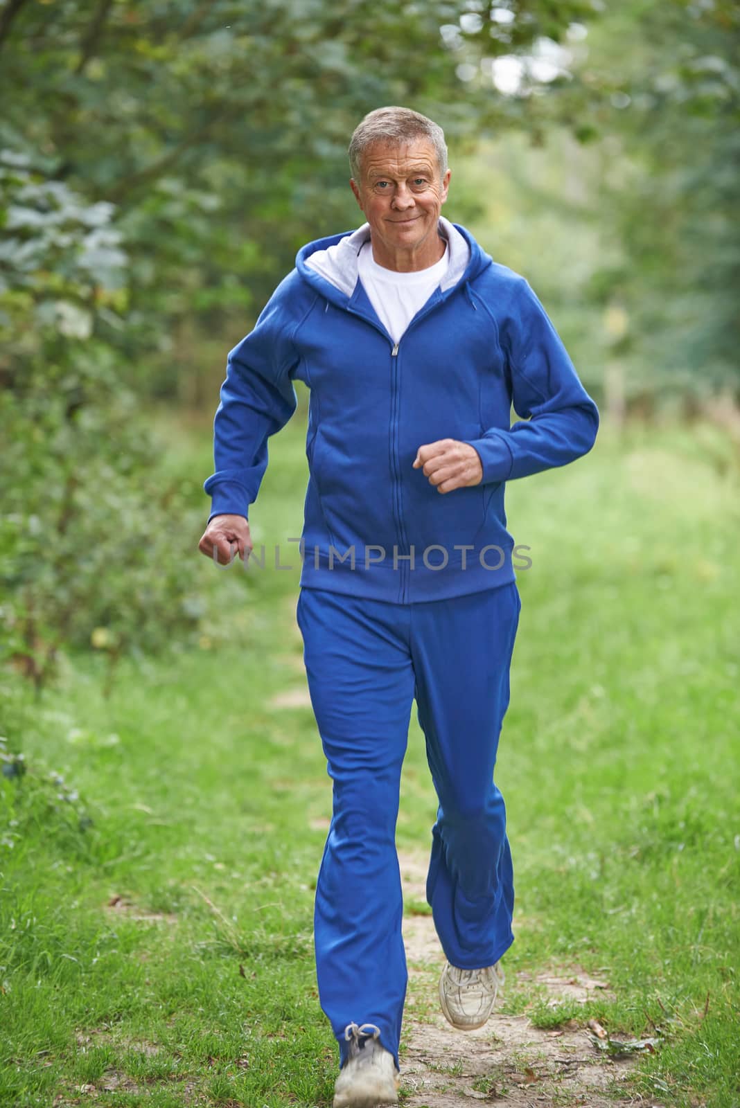 Senior Man In Tracksuit Running Through Countryside  by HWS