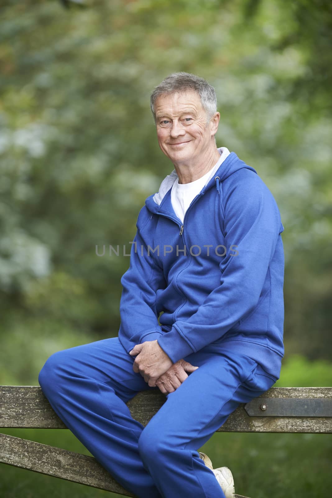 Senior Man Resting Whilst Exercising In Countryside