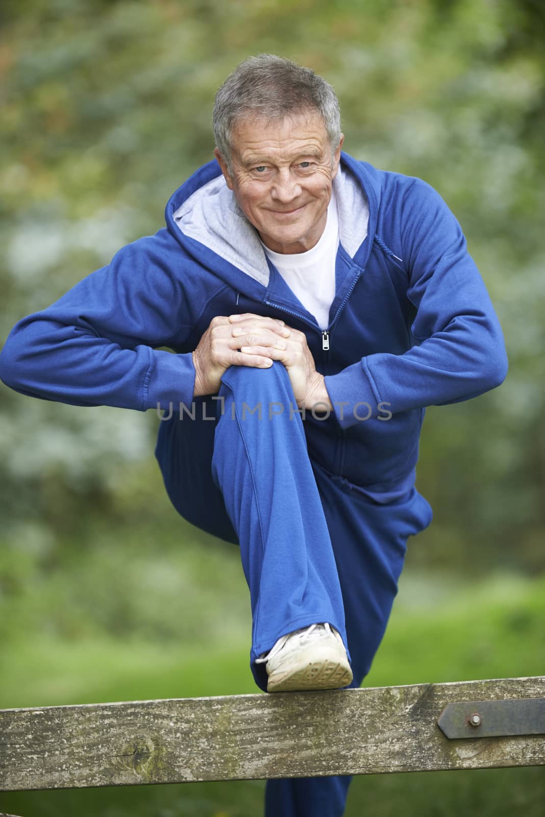 Senior Man Stretching On Countryside Run