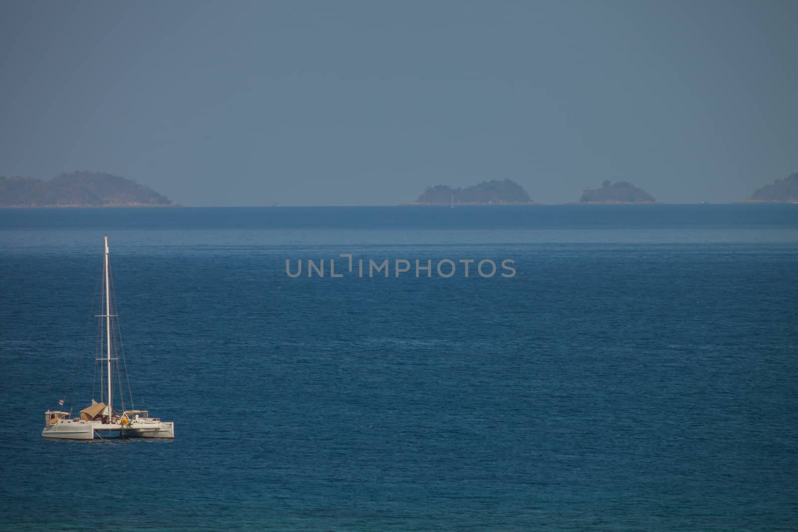 Yacht is parking in tropicana of sea at sunset is reflecting on water located at south of Thailand