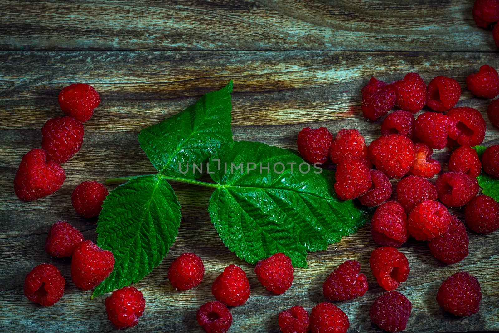 Macro photo raspberry berry. Texture background ripe pink raspberry berry. Fresh raspberries on a rustic wooden table. Selective focus.