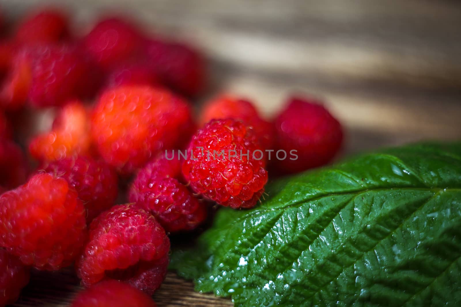Macro photo food raspberry berry. Texture background ripe pink raspberry berry. Fresh raspberries on a rustic wooden table. Selective focus.