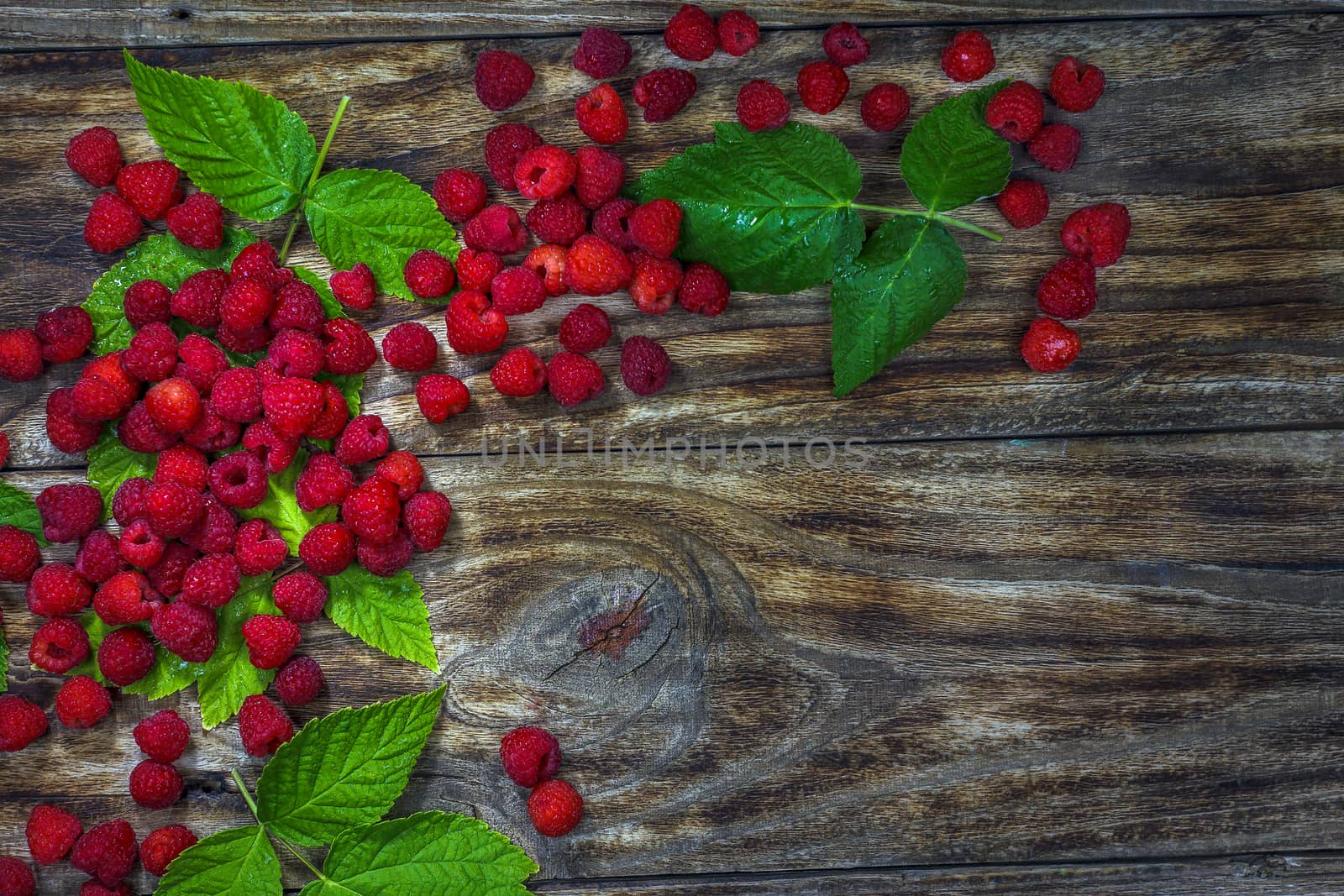 Fresh raspberries background close-up photo. Fresh raspberries on a rustic wooden table. Selective focus.